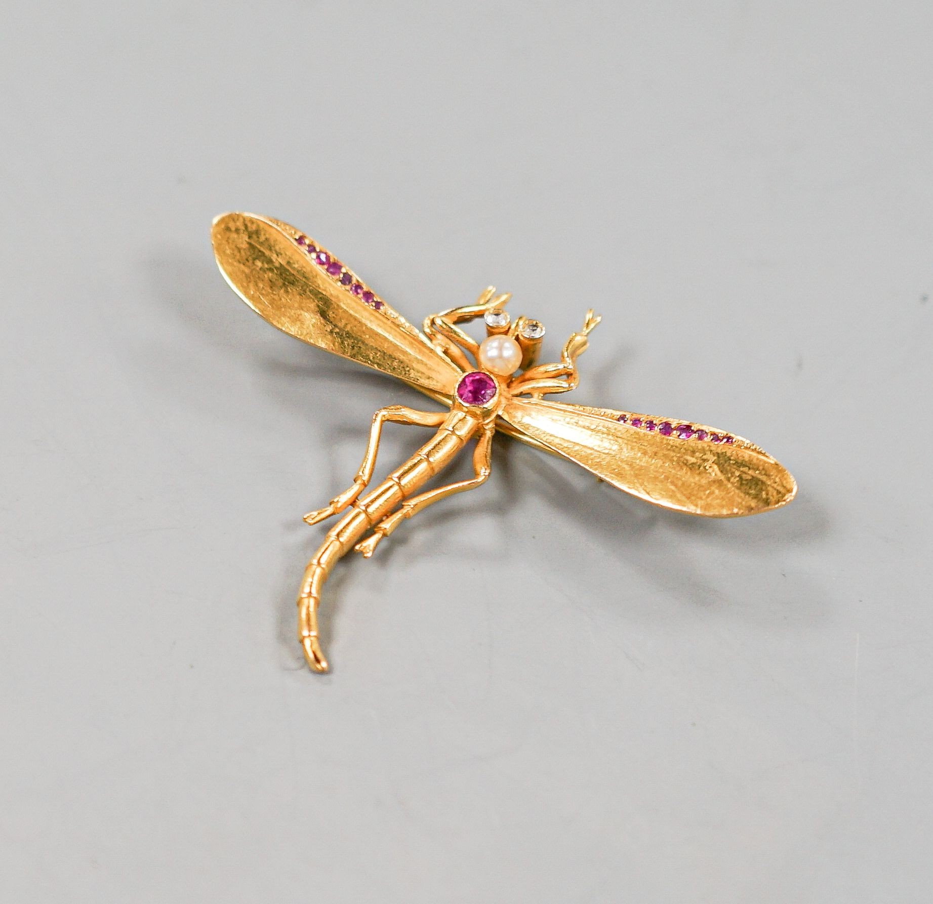 A yellow metal, ruby diamond and cultured pearl set dragonfly brooch, diameter 52mm, gross weight 8 grams.